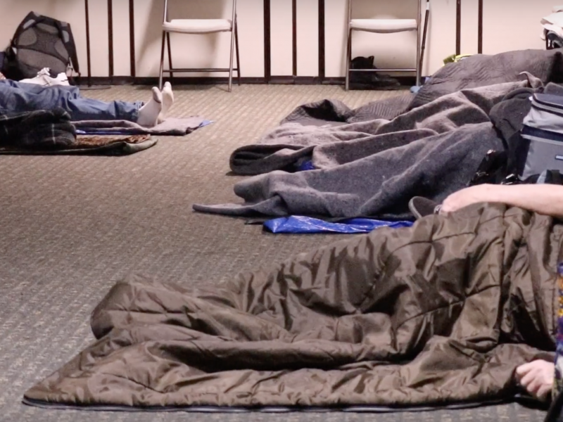 People sleeping in sleeping bags indoors