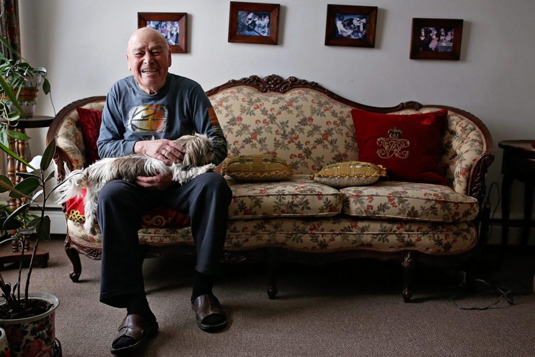 Elderly man sitting on couch with pet