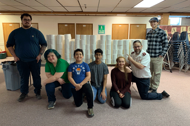 Group of youth in front of toilet paper