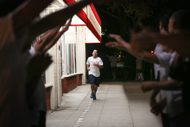 man running towards group with arms raised