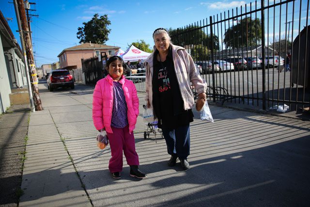 female child and older woman standing outside