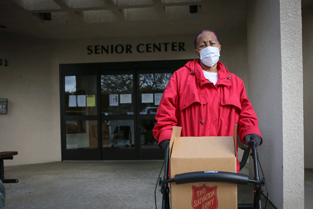 senior with mask on in front of senior center
