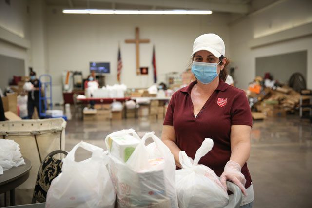 Women with mask on preparing food bags