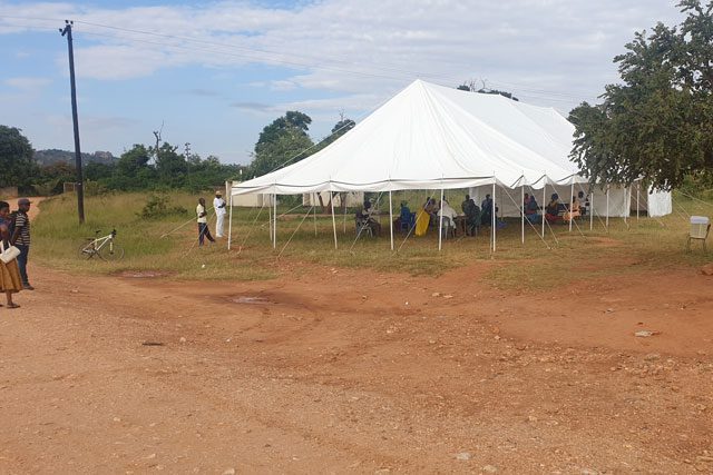 Large canopy set up outside with people underneath