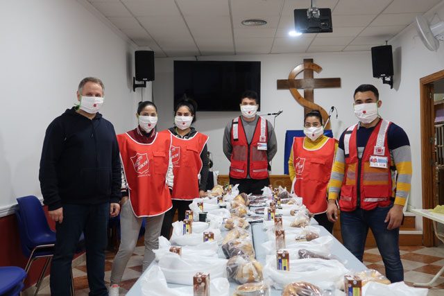 Group of Salvationists with masks on around table