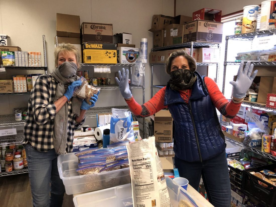 Two people in kitchen with rubber gloves on posing for camera