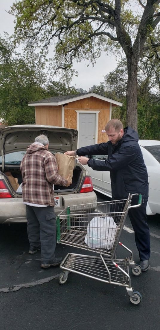 EDS worker helping elderly man with groceries