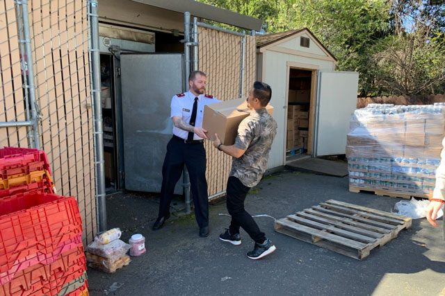 Man handing box to EDS Officer in front of storage area