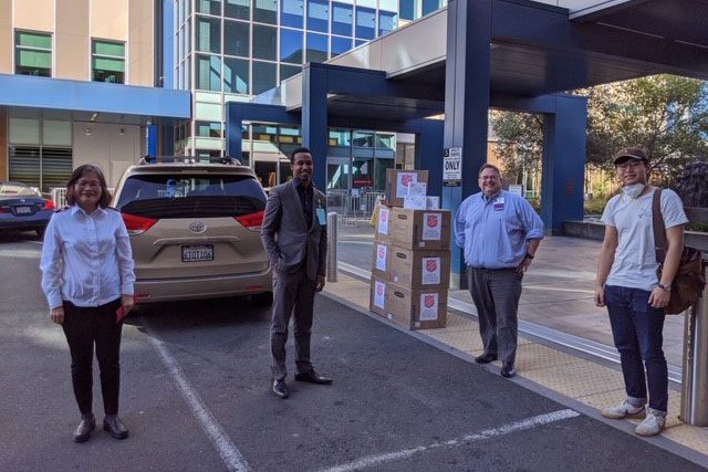 Group of people standing apart from each other with boxes