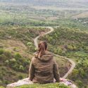 Woman sitting at edge of cliff