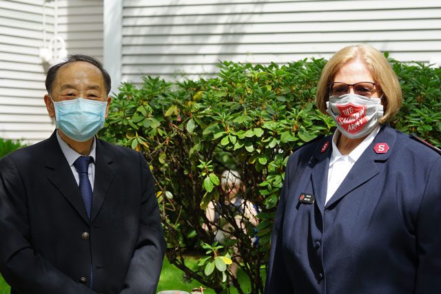 Man and woman in masks standing outside