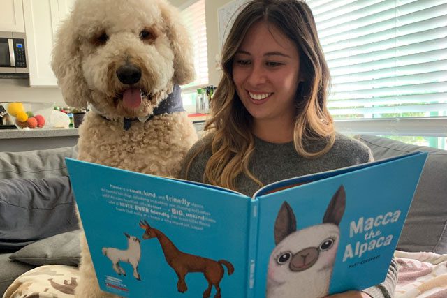 Woman reading book with dog