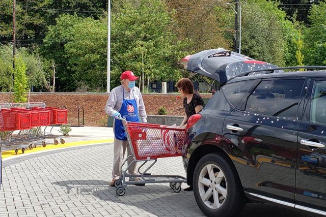Man helping woman load trunk