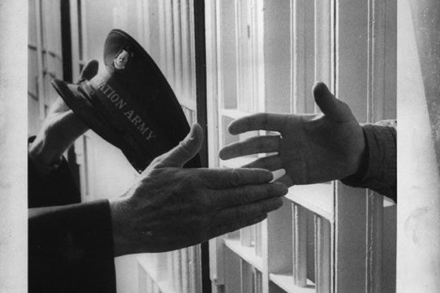 hand reaching through prison bars to shake hand