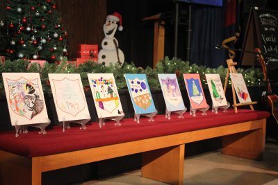 Pictures drawn by children are offered as prizes at an auction.