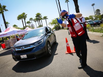 male salvation army officer directs cars at a drive thru food donation event