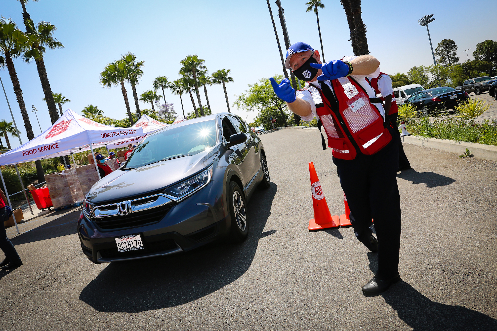 male salvation army officer directs cars at a drive thru food donation event