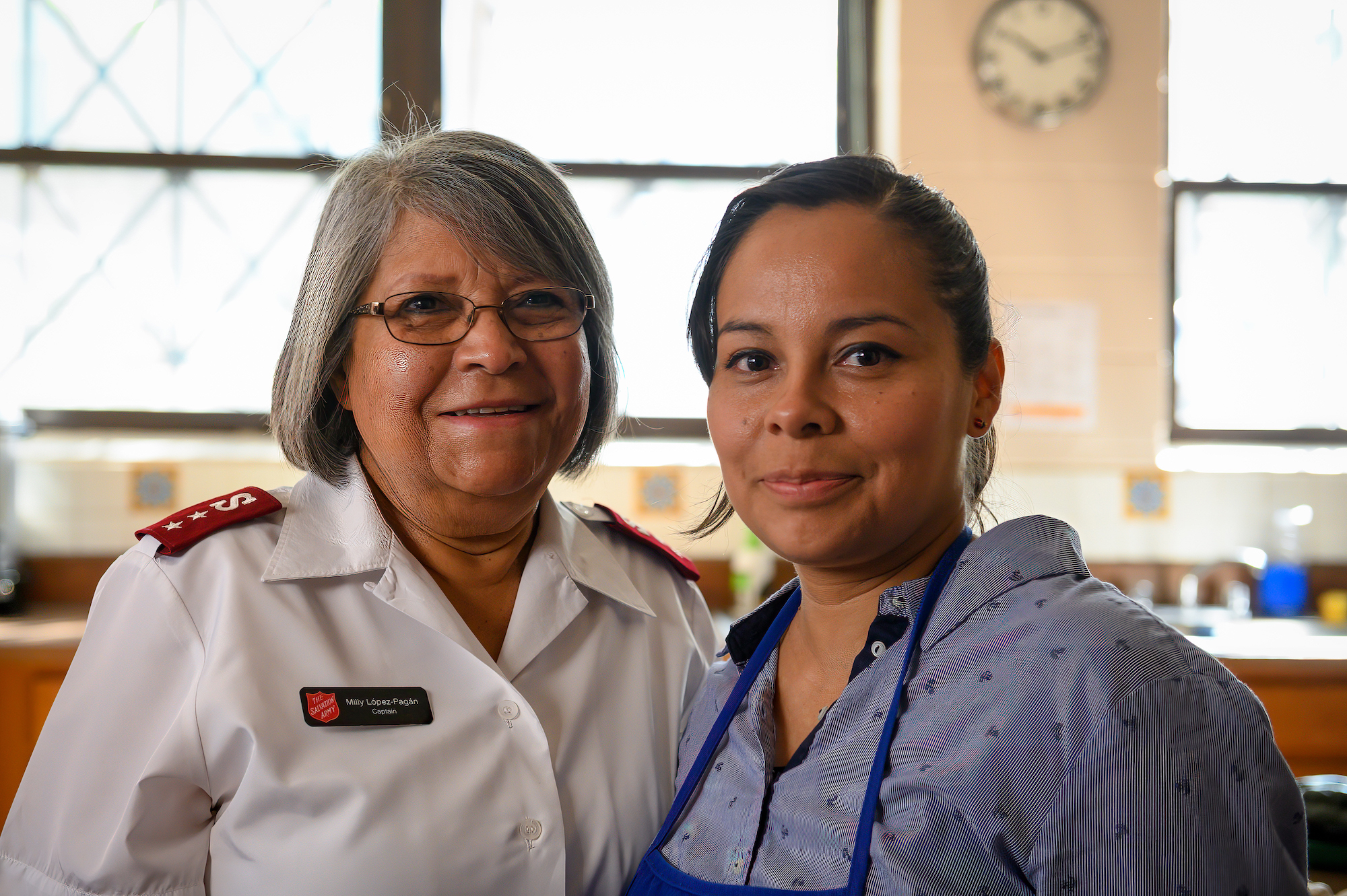 female salvation army officer and female volunteer smile for a photo