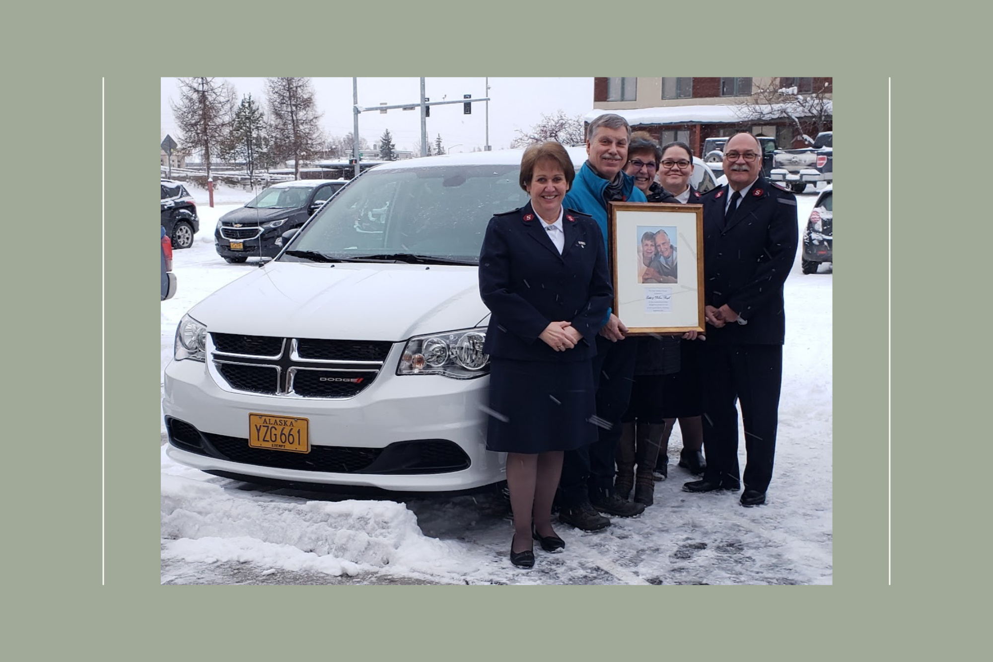 male and female salvation army officers pose for a photo with donors in front of a donated minvan