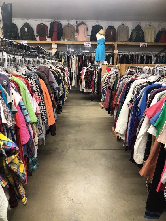image of inside of salvation army thrift store. clothing hangs on racks.