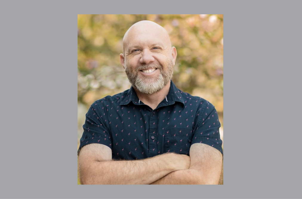 man wearing a navy blue shirt smiling