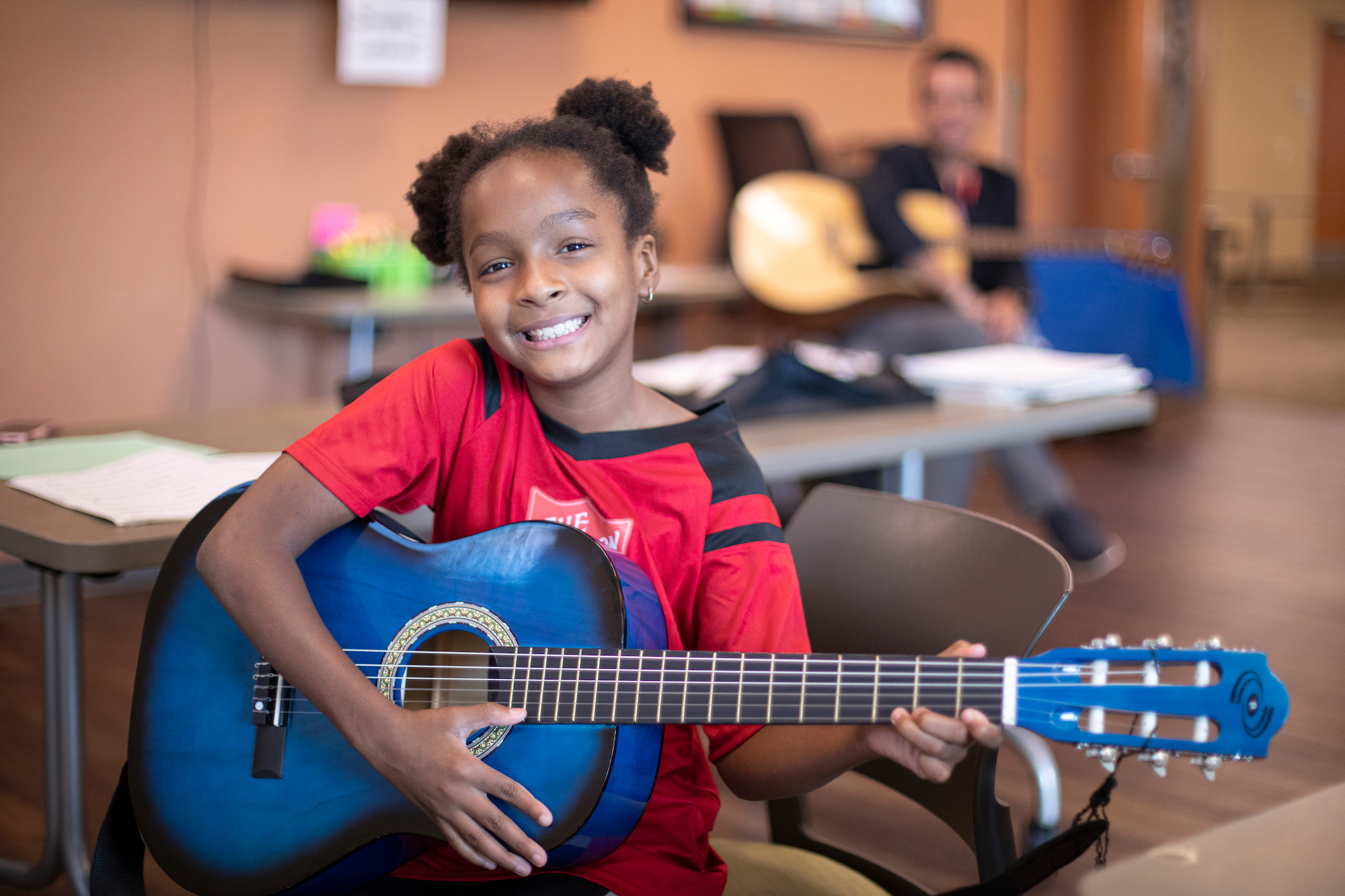 young girl smiling with a guitar