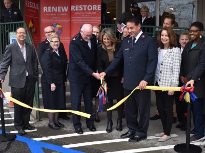 men and women participate in a ribbon cutting ceremony