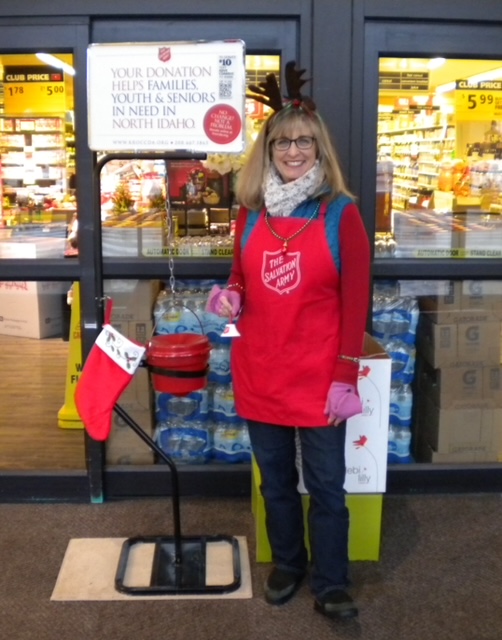 woman volunteers as a bellringer at a salvation army red kettle