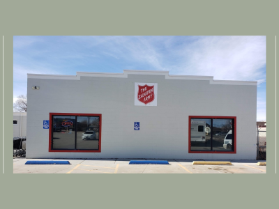 photo of outside of salvation army thrift store. a white building with two windows and a salvation army shield.
