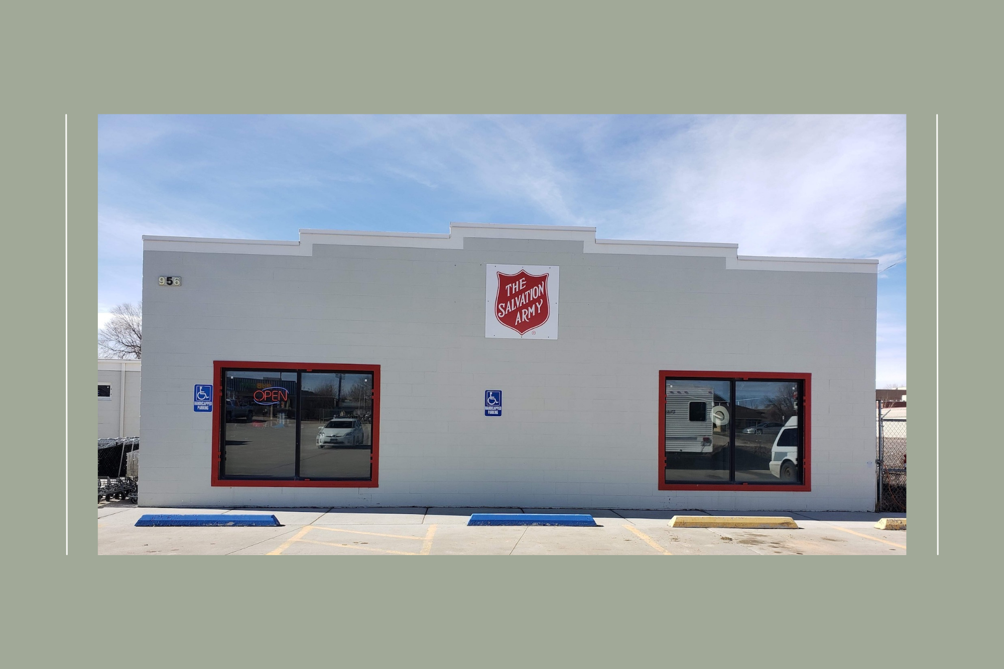 photo of outside of salvation army thrift store. a white building with two windows and a salvation army shield.