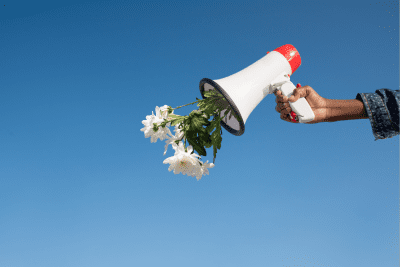 person holding a megaphone with flowers coming out of it