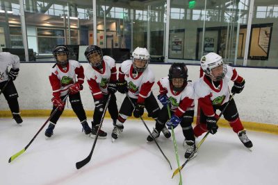 youth participate in an ice hockey camp