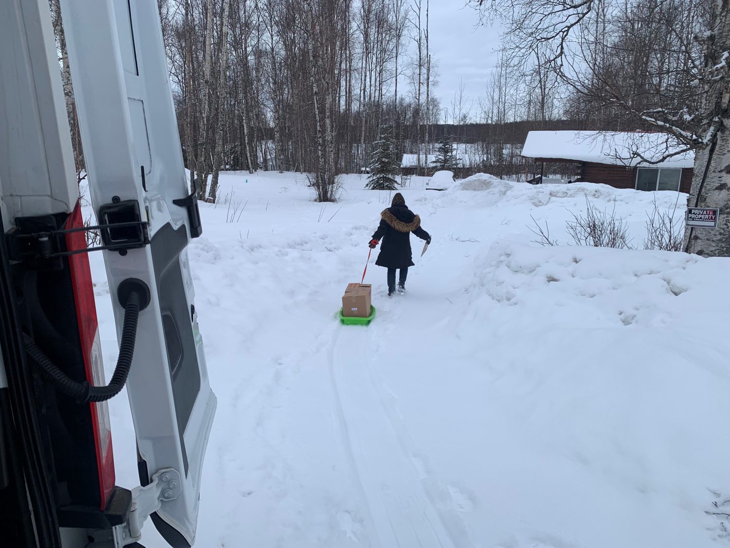 Delivery drivers use sleds to bring food boxes to homebound seniors.